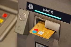 30351337-1 man sieht eine Karte in einem Geldautomat stecken