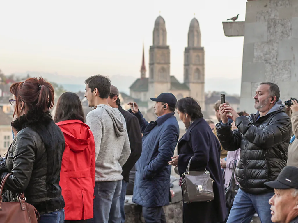 Touristen in Zürich, im Hintergrund ist das Grossmünster zu sehen.