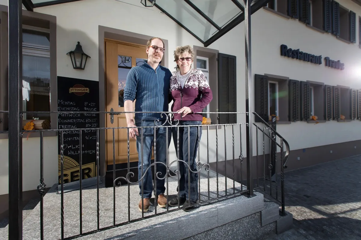 Mann und Frau stehen vor einem Gebäude.